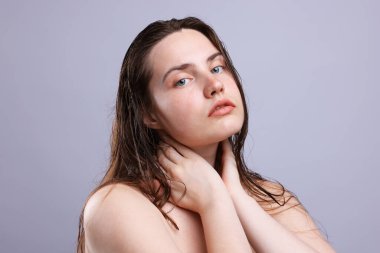 Gri arka planda doğal ten rengi olan kadın portresi, yakın plan.