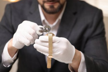 Lüks kol saati değerlendirmesi yapan eksper kapalı alanda, yakın çekim görüntüsü