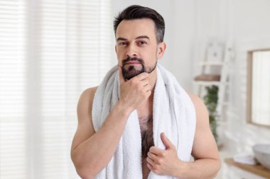 Banyoda tıraş olmadan önce yakışıklı bir adamın portresi.