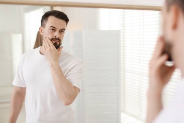 Banyoda aynaya bakmadan önce yakışıklı bir adam.