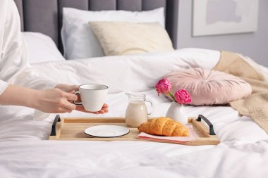 Kadın yatakta nefis bir kahvaltı yapıyor, yakın plan.