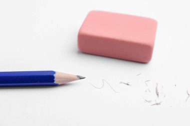 Beyaz arkaplanda kalem, silgi, karalama ve kırıntılar, yakın plan