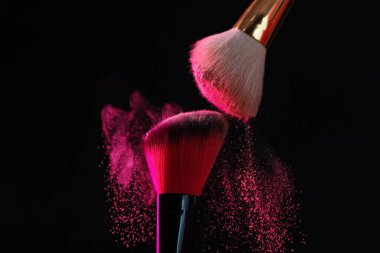 Siyah arka planda pembe göz farlı makyaj fırçaları, yakın plan