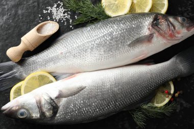 Siyah masada baharatlı taze çiğ deniz kabuğu, düz. Balık ve deniz ürünleri lezzetleri