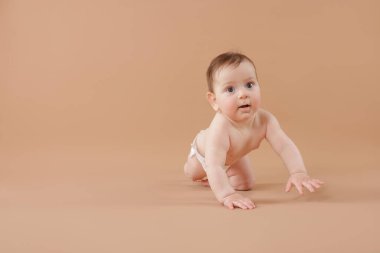 Bej arka planda emekleyen şirin bir bebek. Metin için boşluk