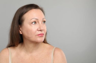 Gri arkaplanda kozmetik prosedüründen önce kadın, metin için boşluk