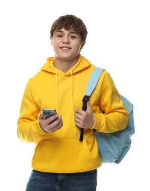 Beyaz arka planda akıllı telefonu ve sırt çantası olan genç bir çocuk.