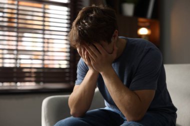 Gençlik sorunları. Evdeki kanepede depresif bir genç çocuk.