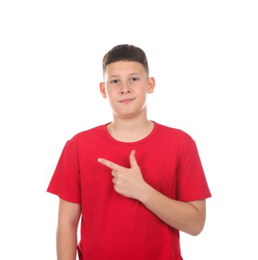 Genç çocuk beyaz arka planda bir şeye işaret ediyor.