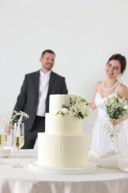 Mutlu evli çift içeride, masadaki düğün pastasına odaklan.