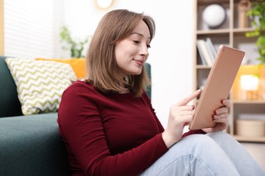 Evde tabletli bir kadın var.