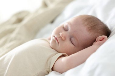 Yeni doğmuş şirin bebek evde yatakta uyuyor.