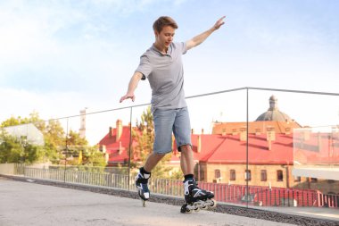 Mutlu adam şehir caddesinde paten kayıyor.