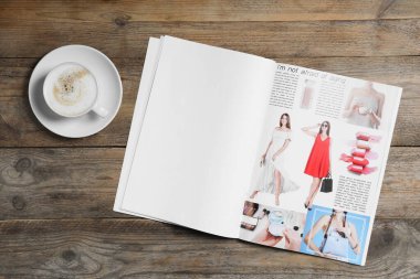 Açık dergi ve bir fincan kahve, ahşap masa, üst manzara. Tasarım için model