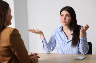 Genç bir kadın iş kadınına şikayet ediyor.