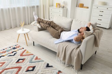 Uyum. Evdeki rahat koltukta dinlenen bir adam.