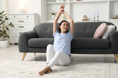 Uyum. Evinde yerde uzanan gülümseyen kadın.