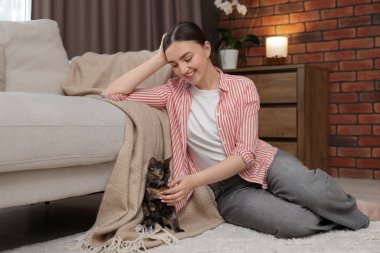 Şirin yavru kedisi evde yerde yatan bir kadın.