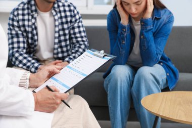 Tüp bebek (tüp bebek). Üreme kliniğinde doktorla görüşen üzgün çift, yakın plan.