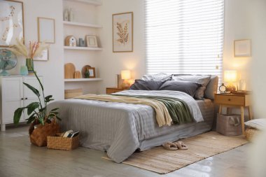 Odasında yumuşak çarşaflar ve battaniyeler olan rahat bir yatak. Ev tekstili