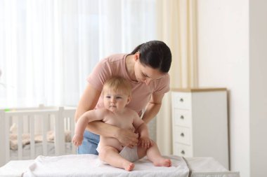 Anne evde bebeğinin bezini değiştiriyor.