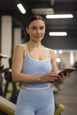 Spor salonunda tableti olan profesyonel kişisel antrenör.