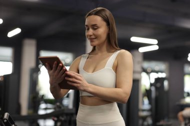 Spor merkezinde tableti olan kişisel antrenör.