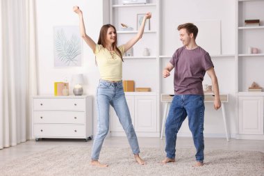 Mutlu genç çift evde dans ediyor.