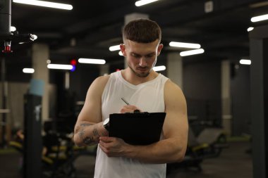 Spor merkezinde panosu olan kişisel antrenör.