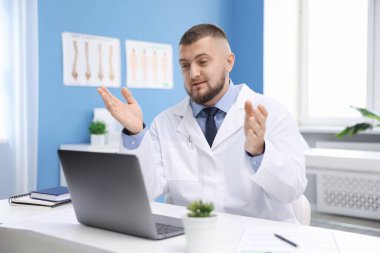 Klinikte bilgisayarla online danışmanlık yapan bir doktor