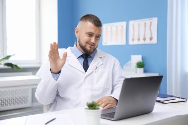 Klinikte bilgisayarla online danışmanlık yapan bir doktor