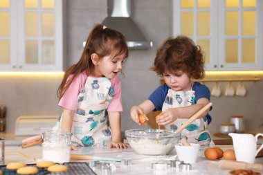 Yemek tarifi. Sevimli çocuklar mutfaktaki masada kurabiye için para kazanıyor.