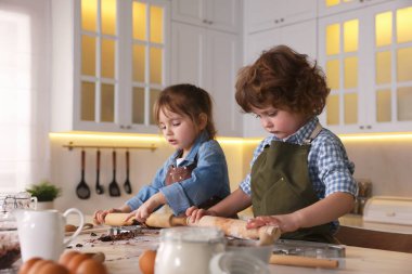 Yemek tarifi. Küçük çocuk mutfaktaki masada kurabiye yapıyor.