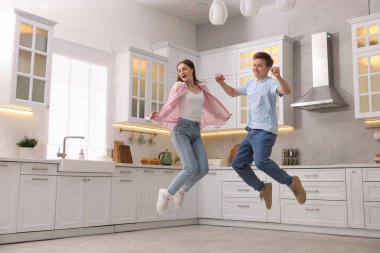 Mutfakta dans ederken zıplayan mutlu çift.