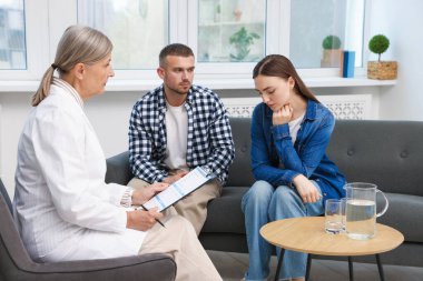 Tüp bebek (tüp bebek). Üreme kliniğinde doktorla görüşen üzgün çift.