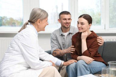 Tüp bebek (tüp bebek). Doktor, üreme kliniğinde genç çiftleri teşvik ediyor.