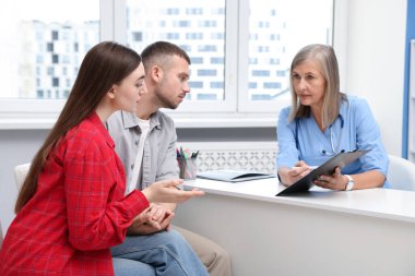 Tüp bebek (tüp bebek). Çift, üreme kliniğinde doktorla görüşüyor.