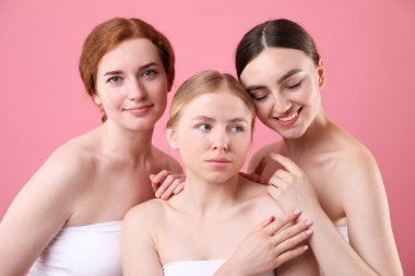 Pembe arka planda farklı saç renkleri olan güzel kadınlar.