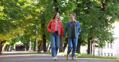 Güzel bir çift parkta birlikte yürüyor, alçak açılı bir manzara.