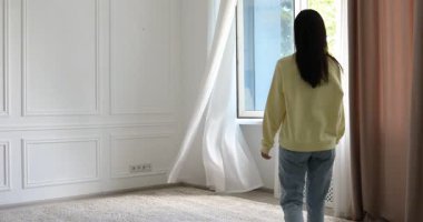 Uyum. Gülümseyen kadın evdeki açık pencerenin yanında geriniyor.