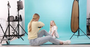 Profesyonel fotoğraf stüdyosunda modelle çalışan bir fotoğrafçı.