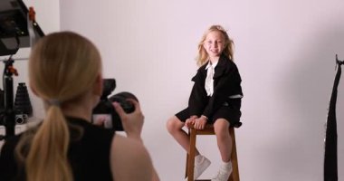 Profesyonel fotoğraf stüdyosunda modelle çalışan bir fotoğrafçı.