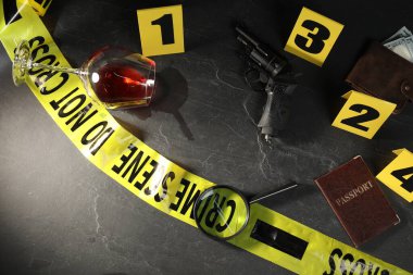 Adli tıp uzmanı. Sarı olay yeri bandı, siyah masanın üstünde işaretler ve kanıtlar var.