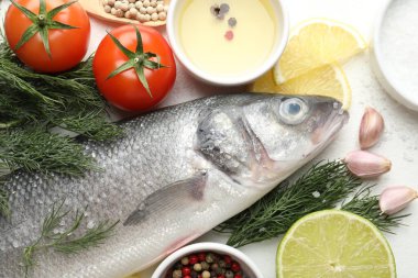 Taze çiğ deniz kabuğu ve beyaz masa üzerinde baharatlar. Balık ve deniz ürünleri lezzetleri