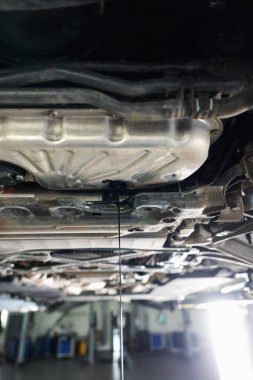 Araba motorundan damlayan eski kirli motor yağı atölyede, yakın plan.