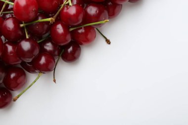Beyaz arka planda taze kirazlar, düz uzanmış. Metin için boşluk