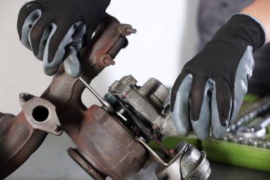 Otomobil parçaları. Kapalı bir masada turbo şarj aleti tamir eden profesyonel bir tamirci.