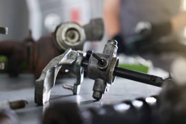 Otomobil parçası. Kapalı alandaki gri masada elle iletim.