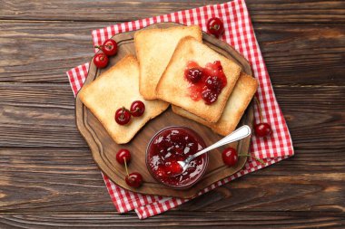 Lezzetli kiraz reçelli tostlar ve ahşap masada taze meyveler.