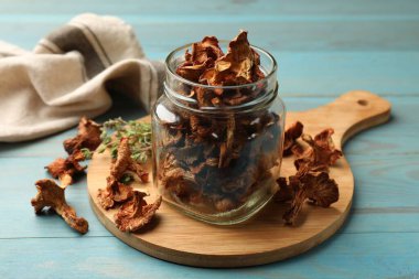 Mavi ahşap masadaki kekik mantarlı kurutulmuş chanterelle mantarı.